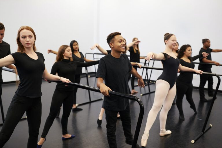 male-and-female-students-at-performing-arts-school-rehearsing-ballet-in-dance-studio-using-barre.jpg